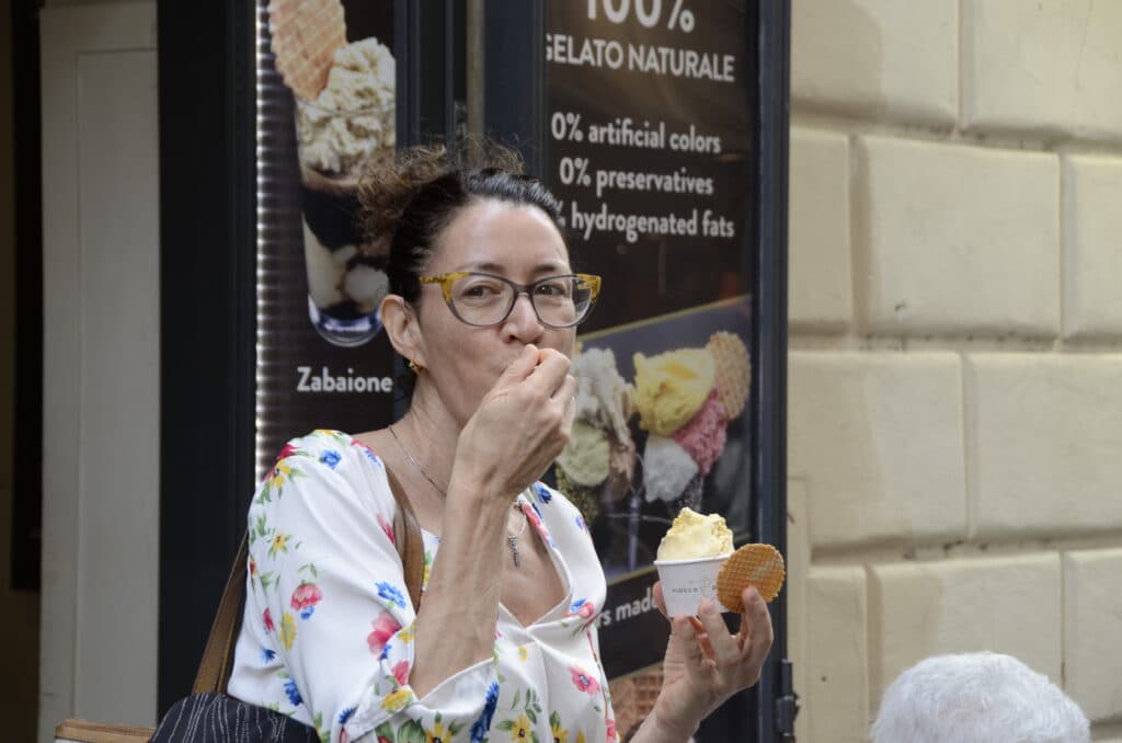 A guest tasting gluten-free gelato outside a shop in Rome
