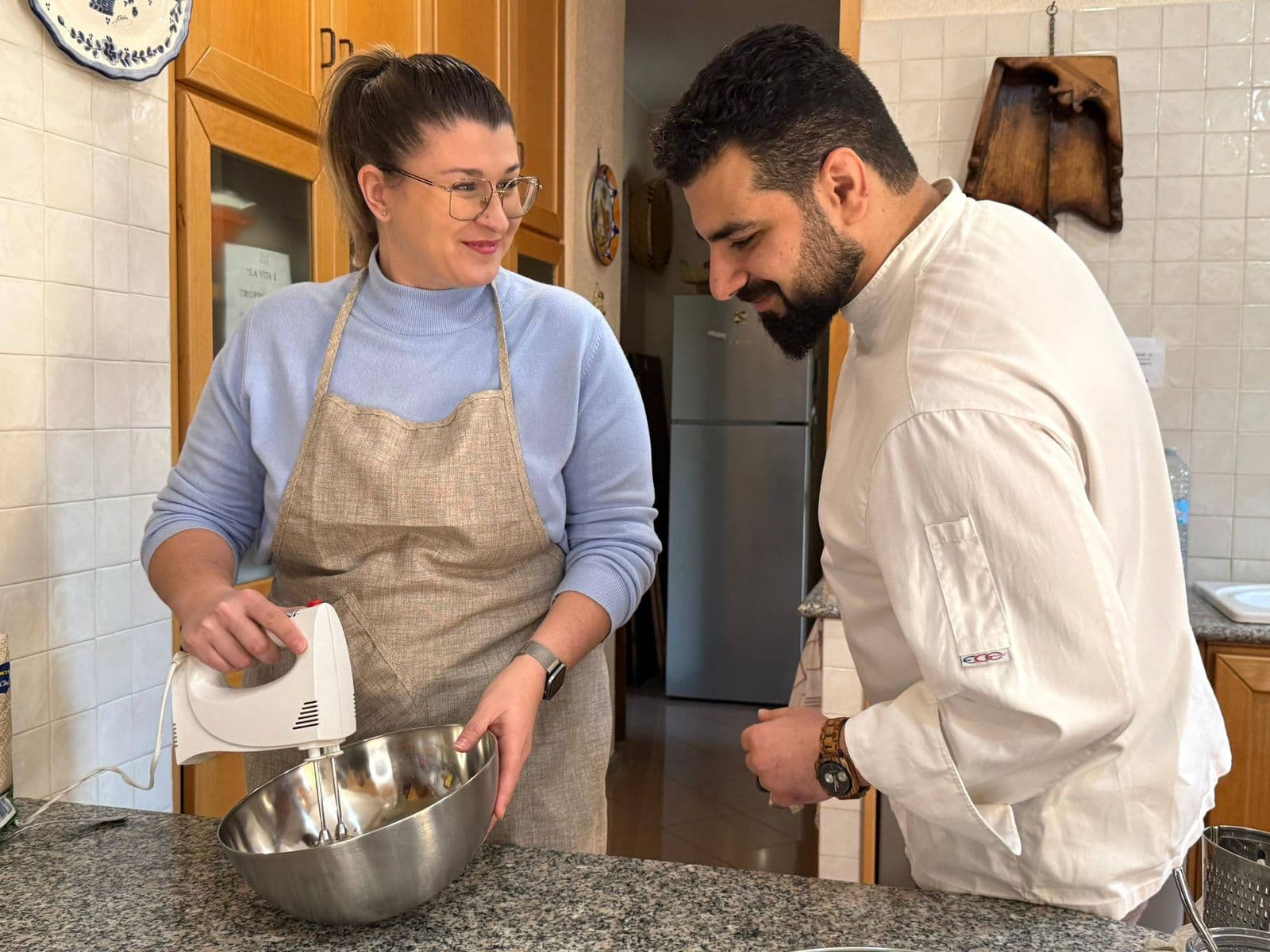 A guest and chef mixing dough in the gluten-free cooking class in Rome